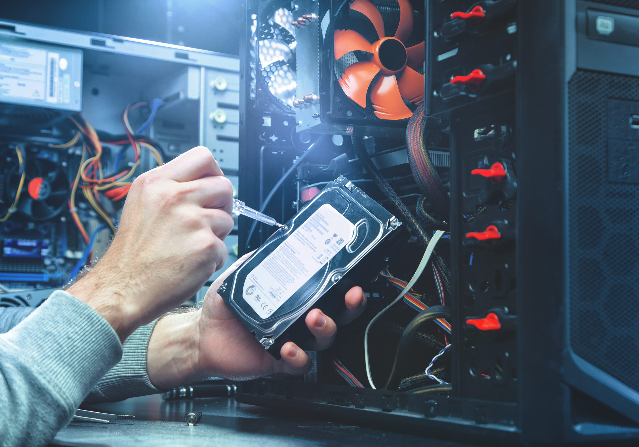 Technician repairing a computer, the process of replacing components on the motherboard. The technician hold the screwdriver for repairing PC. The concept of computer hardware, repairing, upgrade and technology